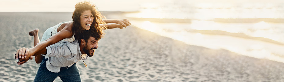 Mit der easyCredit Finanzreserve bis zu 75.000 Euro Spielraum sichern Junges Paar genießt die finanzielle Freiheit am Strand